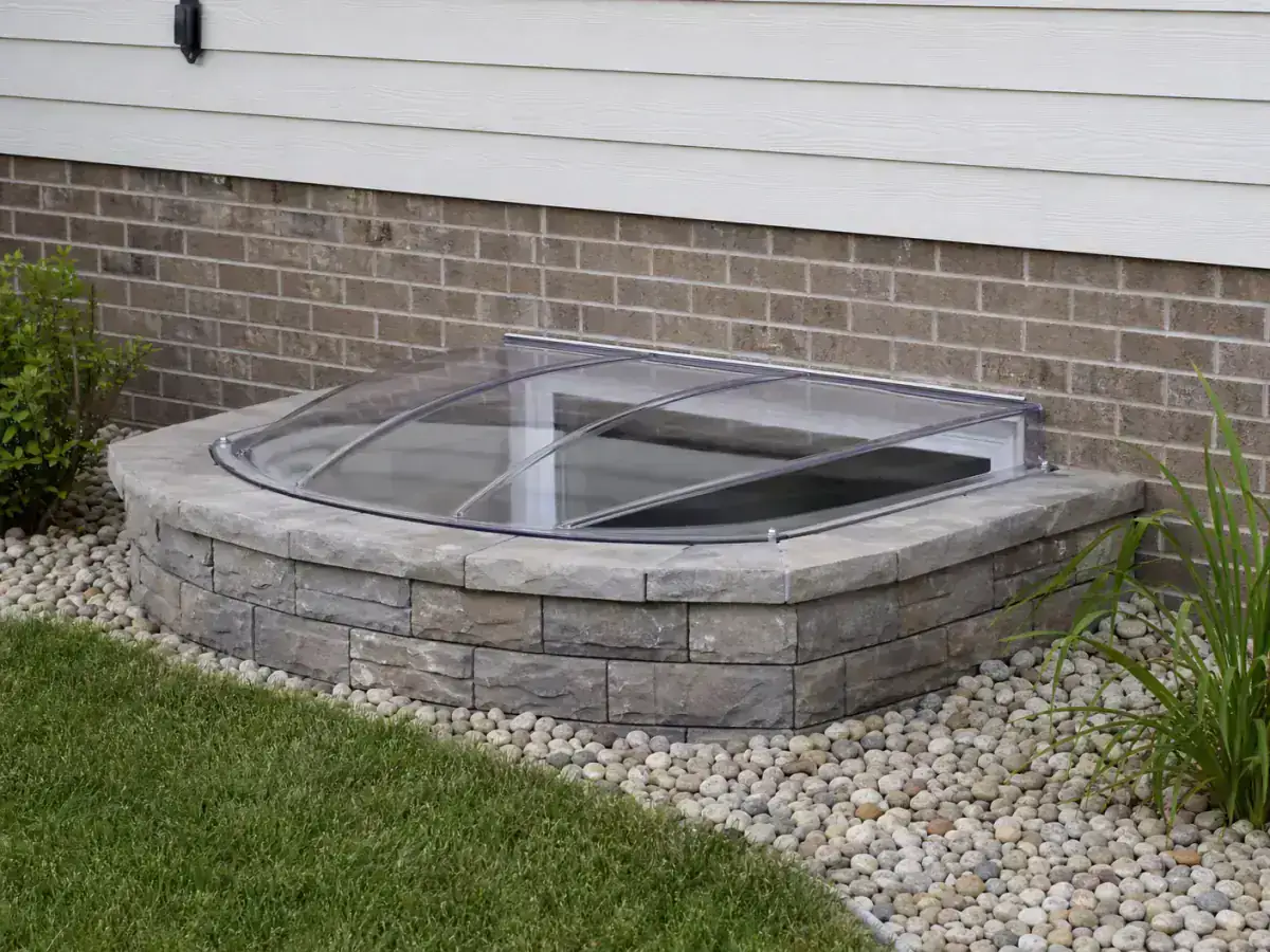 Completed exterior egress window and foundation detail showing professional window well installation in Iowa